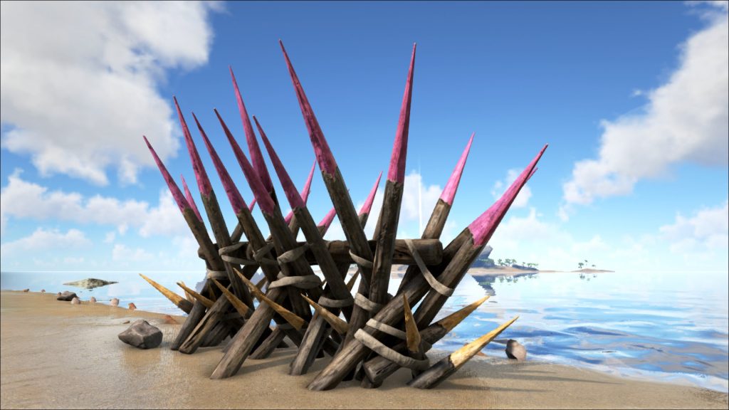 Large wooden defensive spikes on a beach.